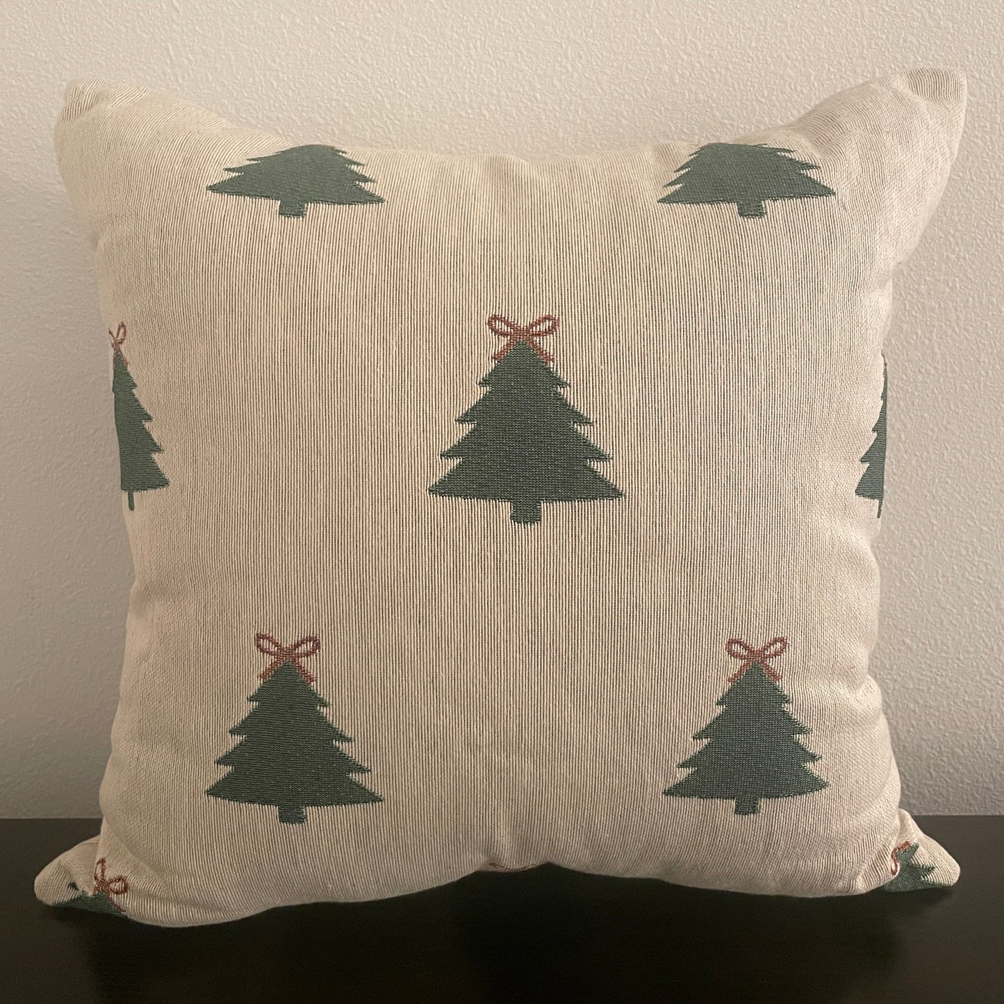Neutral woven Christmas pillow featuring green Christmas trees with red bows, perfect for rustic farmhouse or minimalist holiday décor.