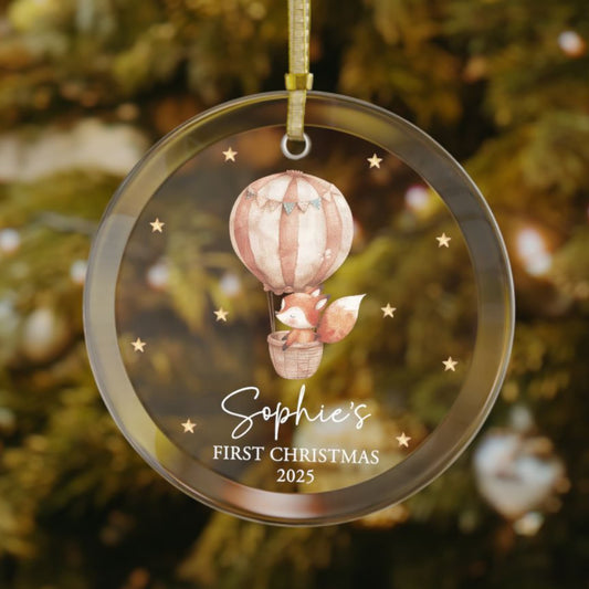 Custom baby’s first Christmas glass ornament with cute fox in an air balloon, stars scattered in the background, personalized with baby name and year, holiday decoration for Christmas tree