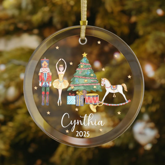 Custom ballet-themed glass Christmas ornament showcasing a ballerina, nutcracker, Christmas tree, rocking horse, and presents with personalized name and year.