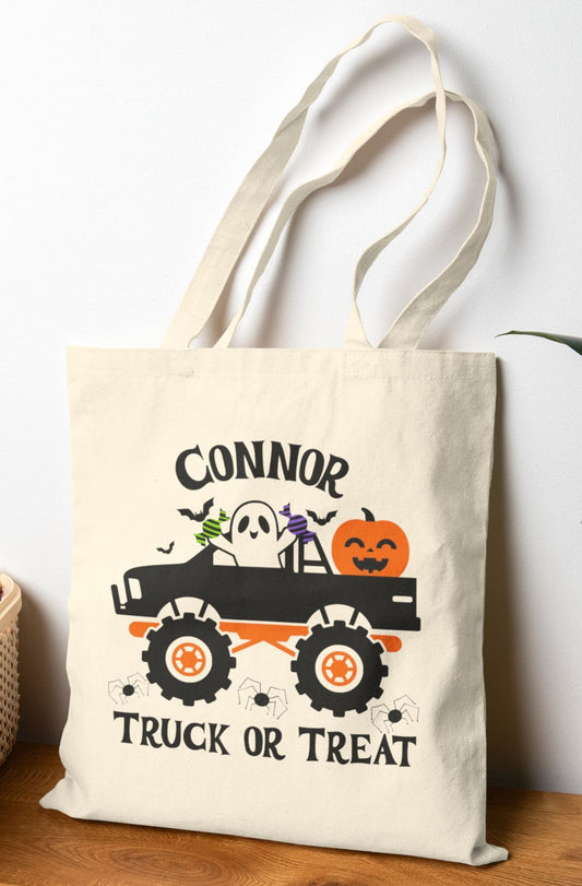Custom Halloween tote bag with name "Connor" – spooky ghost in a monster truck, holding candy with jack-o’-lantern, bats, and “Truck or Treat” text.