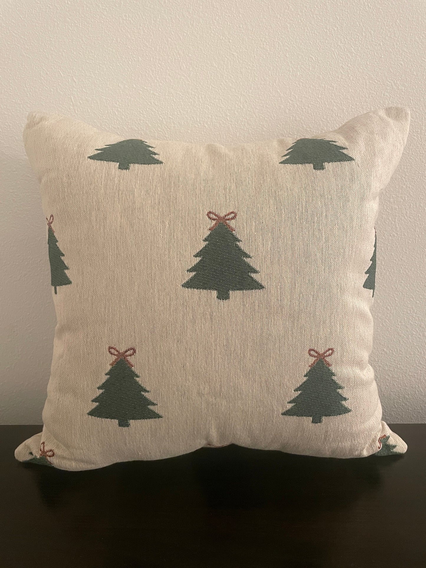 Neutral woven Christmas pillow featuring green Christmas trees with red bows, perfect for rustic farmhouse or minimalist holiday décor.