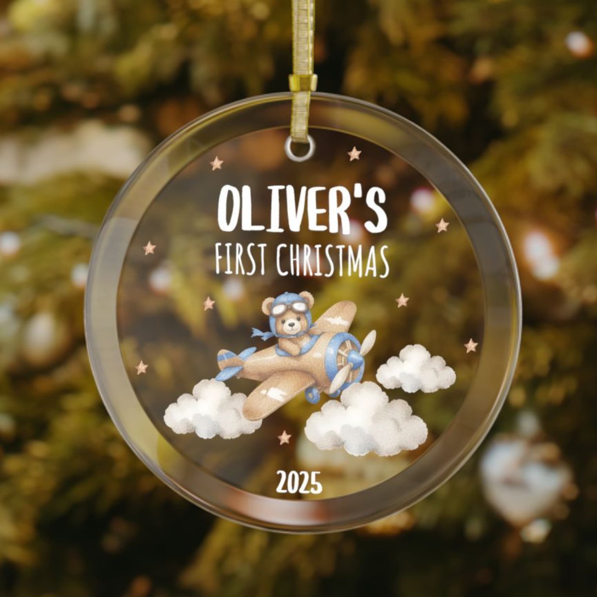 Personalized baby’s first Christmas glass ornament with teddy bear flying an airplane through clouds, with stars scattered in the background, custom name and year keepsake, holiday decoration for Christmas tree