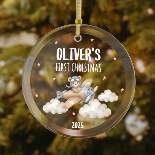 Personalized baby’s first Christmas glass ornament with teddy bear flying an airplane through clouds, with stars scattered in the background, custom name and year keepsake, holiday decoration for Christmas tree