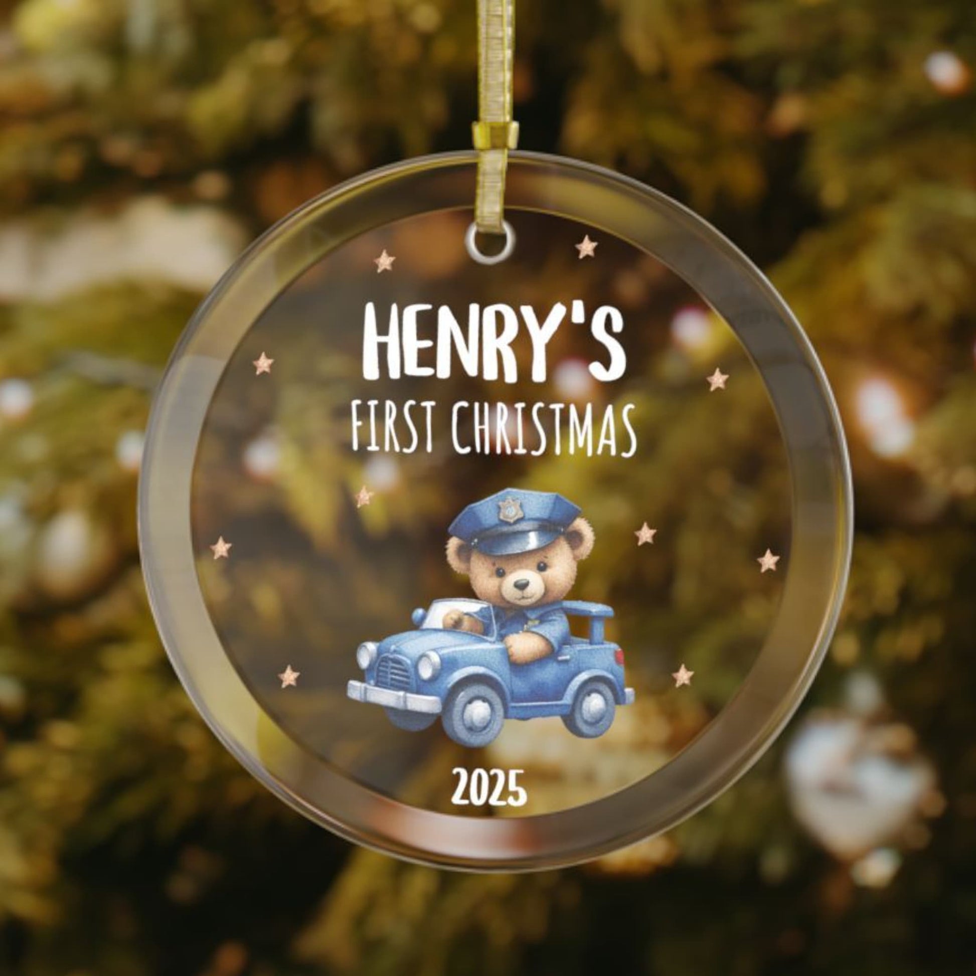 Personalized baby’s first Christmas glass ornament with teddy bear driving a toy police car, stars scattered in the background, custom name and year keepsake, holiday decoration for Christmas tree