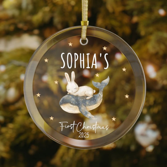 Personalized baby’s first Christmas glass ornament with bunny resting on a whale, stars scattered in the background, custom baby name and year keepsake, holiday decoration for Christmas tree
