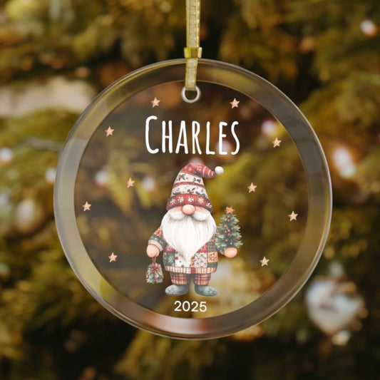 Personalized gnome glass Christmas ornament featuring a festive gnome holding a small Christmas tree, with custom name and year, and light golden-brown stars in the background - a charming holiday keepsake.