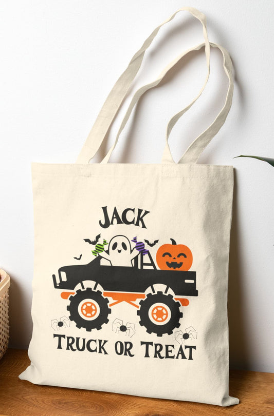 Personalized Halloween tote bag with custom name – features a spooky ghost driving a monster truck with candy, jack-o'-lantern, bats, and the phrase "Truck or Treat".